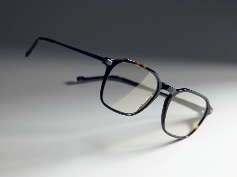 Barna keretbe helyezett, átlátszó lencsékről készült kép, amelyeken a ZEISS DuraVision Gold UV halvány arany árnyalata látszik.
