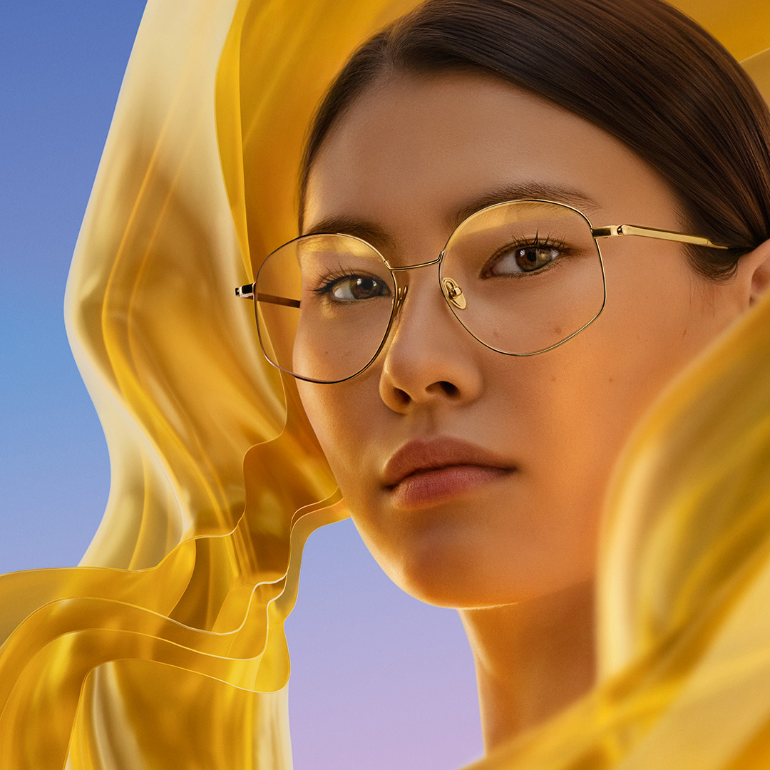 ZEISS DuraVision Gold UV tükröződésgátló szemüveglencse-bevonattal ellátott szemüveget viselő nő, a lencsén halvány aranyszínű fényvisszaverődés látható.