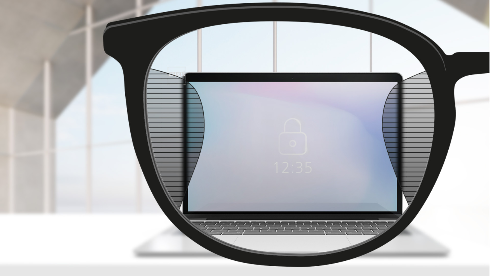Személyes nézőpontból készült kép egy ZEISS Office szemüveglencséről, amelynek közepén egy számítógép képernyője látszik, a lencse bal és jobb oldalán pedig apró homályos részek látszanak.