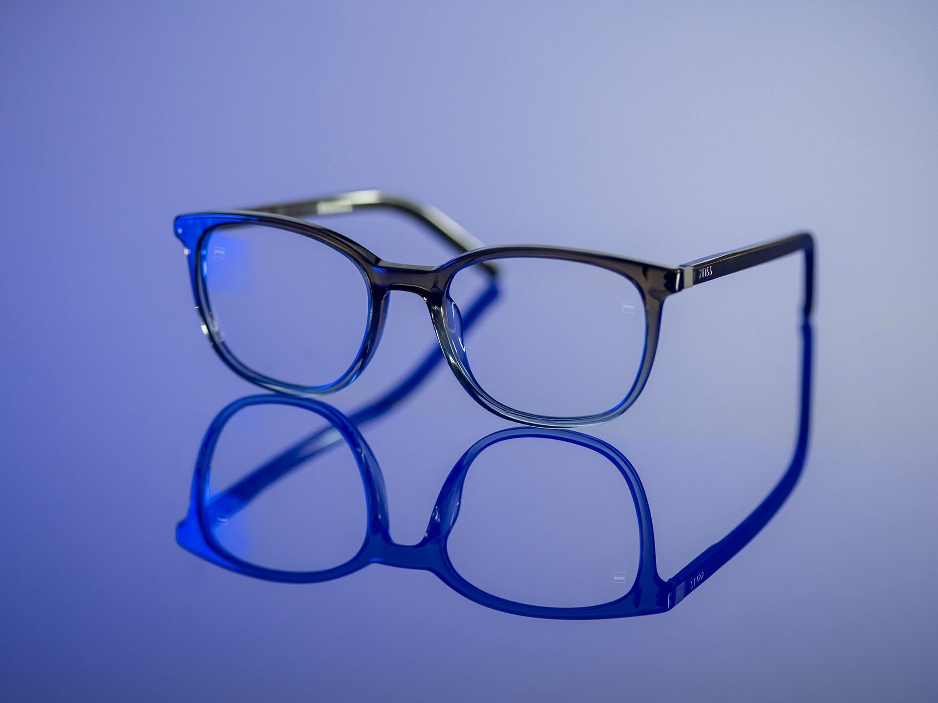 Kék fénynek kitett, BlueGuard alapanyaggal ellátott ZEISS szemüveglencse. Csak nagyon enyhe kékes tükröződés látszik a lencséken.