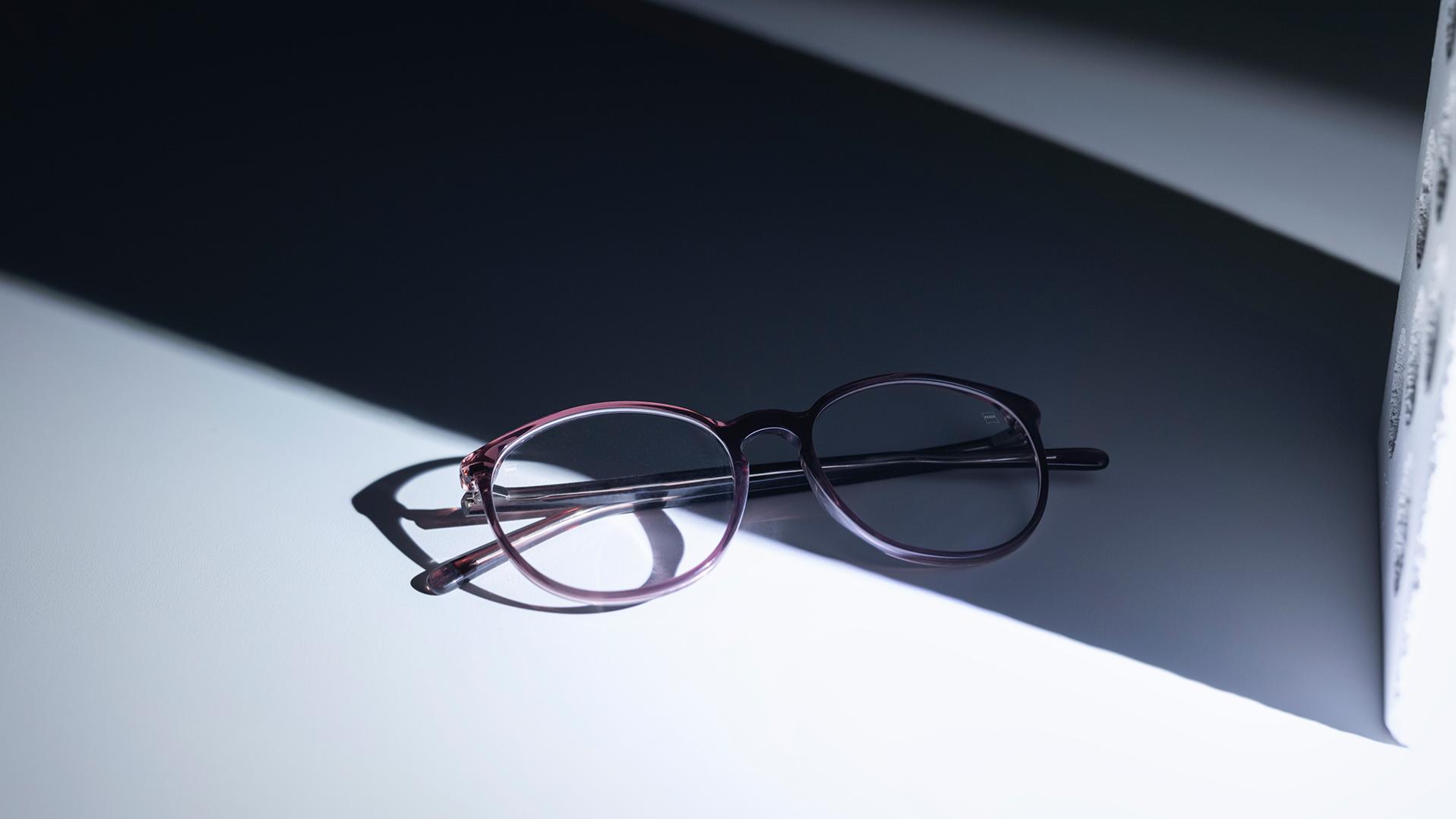 ZEISS lencsékkel és DuraVision® felületkezeléssel ellátott szemüvegek, amelyek félig az árnyékban, félig a napsütésben helyezkednek el.