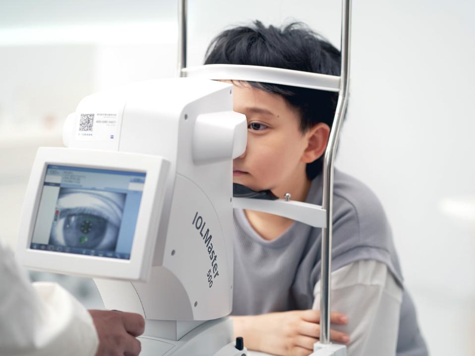 Egy fiatal fiú szemeit a ZEISS IOLMaster készülékkel vizsgálják.