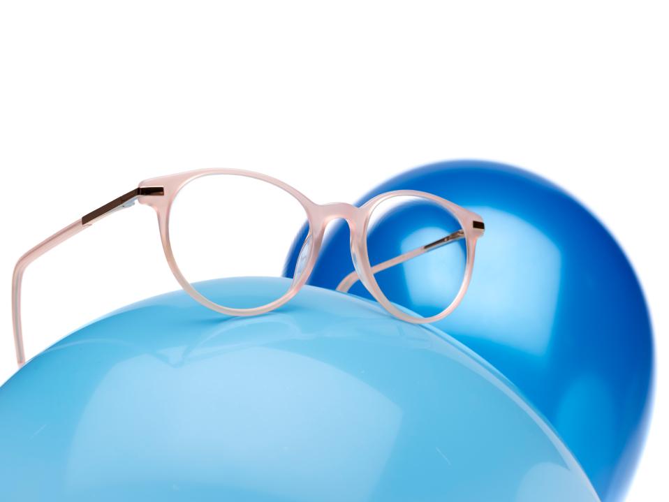 ZEISS Myocare szemüveglencsék rózsaszín szemüvegkeretben, egy kék léggömbön.