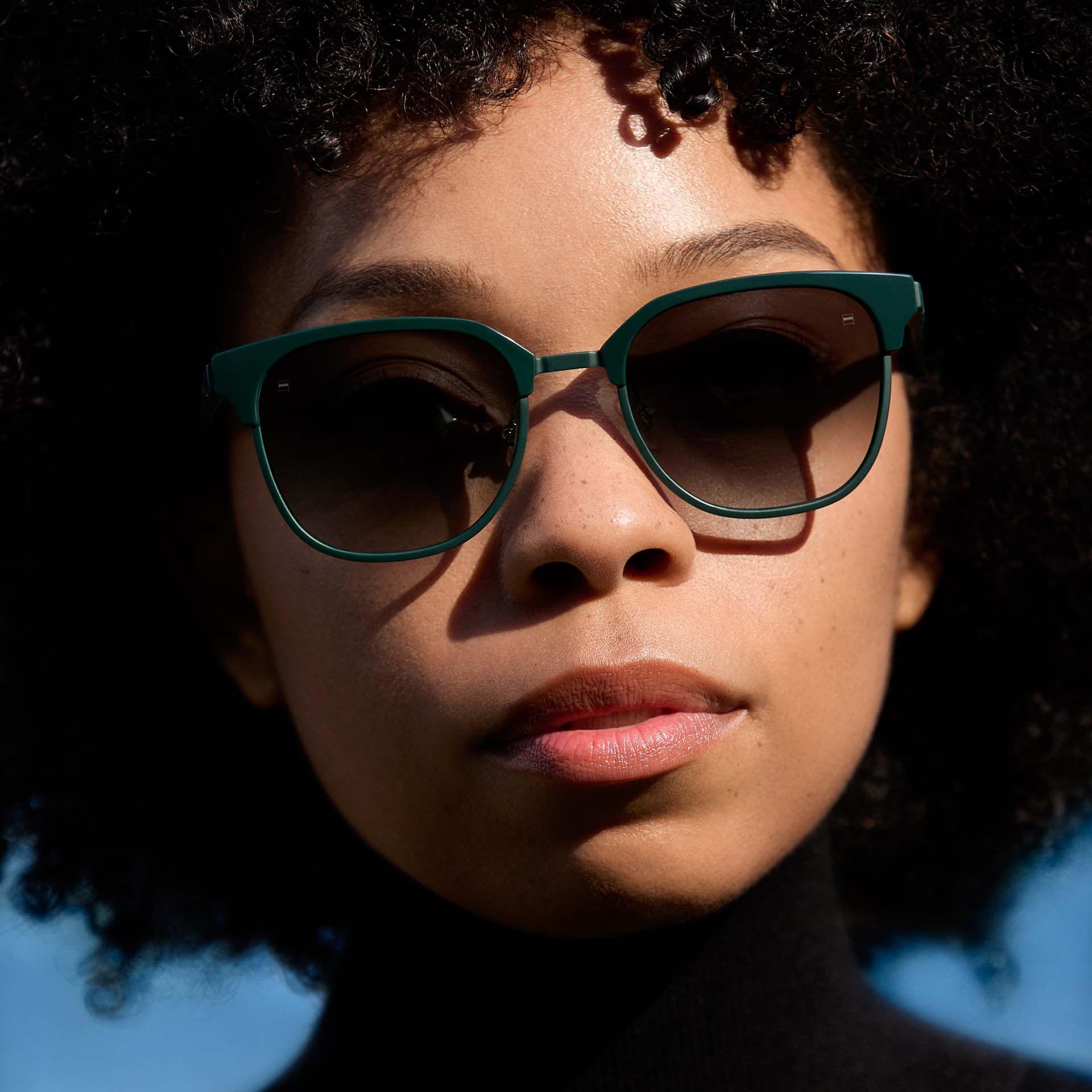 Zöld keretet viselő nő, a lencsék színátmenetes árnyalatúak. 