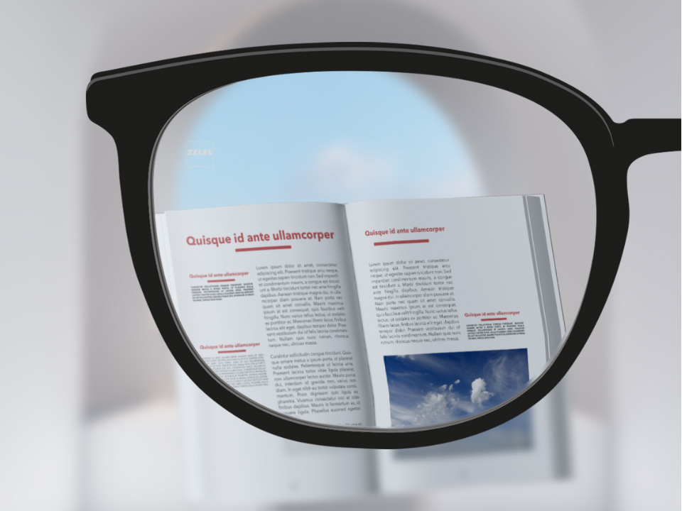 Egy saját szemszögből készült kép egy ZEISS ClearView egyfókuszú szemüveglencséről, amelyen keresztül élesen látszik egy könyv és a háttér, kivéve a szemüveglencse egy vékony része a keret közelében. 