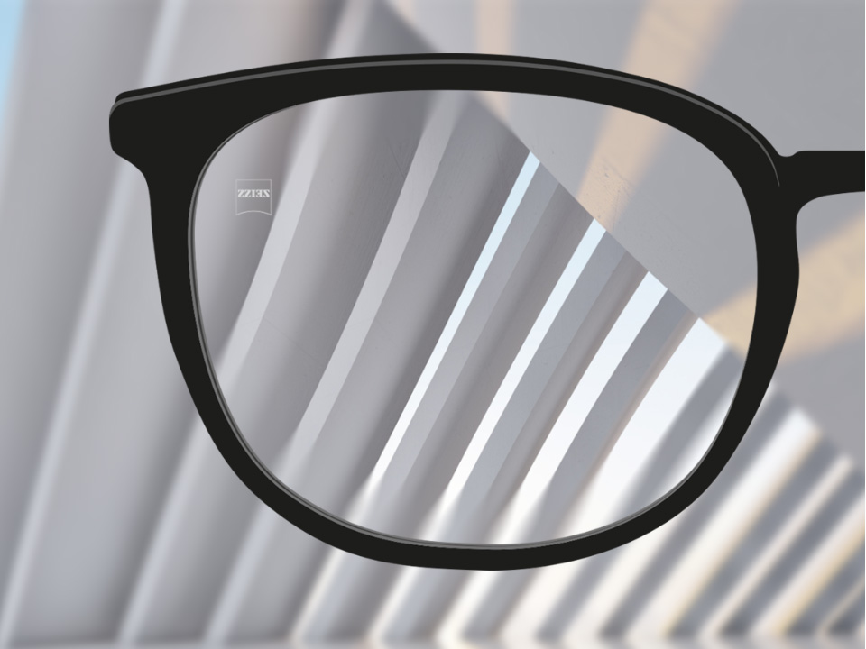 Egy saját szemszögből készült kép egy ZEISS ClearView egyfókuszú szemüveglencséről, amelyen keresztül élesen látszik a háttér, kivéve a szemüveglencse egy vékony részét a keret közelében.