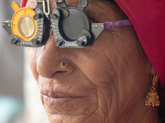 Próbaszemüveget viselő idősebb nő.