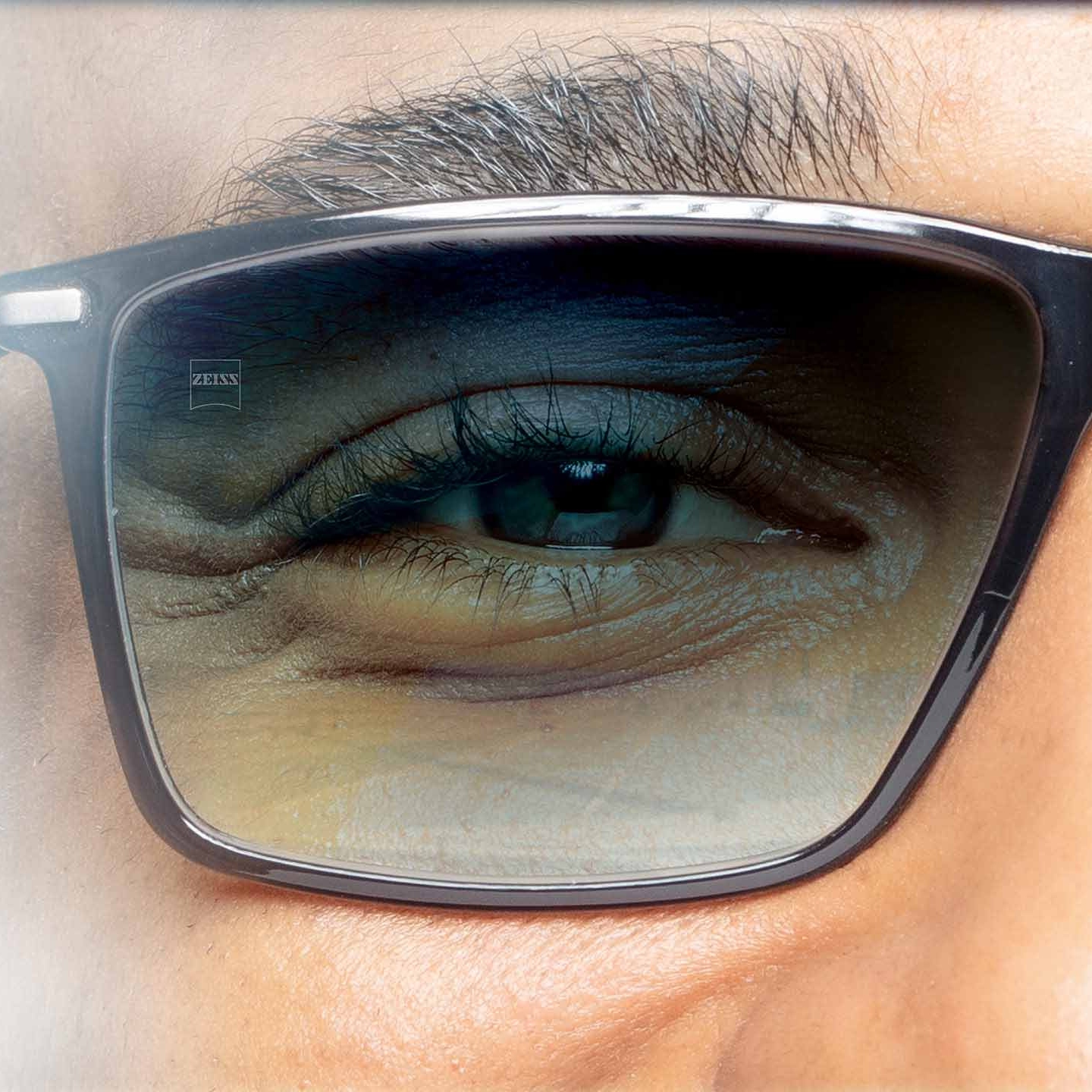 A napfény elleni védelemre tervezett, hátsó és elülső szemüveglencse-rétegekkel ellátott ZEISS színezett lencsét bemutató ábra